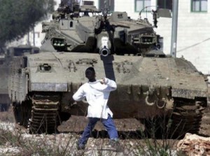 Faris Odeh throws a stone at an Israeli tank near the Israel-Gaza border, October 29, 2000, during the 2nd Palestinian Intifada (ten days before the IDF gunned him down in Gaza). (http://socialistworker.org).