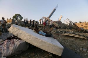 A Palestinian boy rests on a mattress next to the rubble of a house destroyed in an Israeli airstrike, Gaza City, July 9, 2014. (Reuters; http://www.dailymail.co.uk).