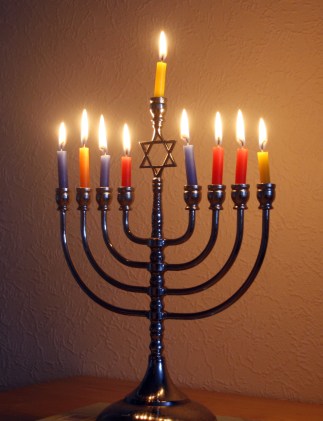 A contemporary Candelabrum in the style of a traditional Menorah. United Kingdom, Chanukah service, December 2014. (Gil Dekel; http://www.poeticmind.co.uk; via 39james via Wikipedia). Released to public domain via CC-SA-4.0.
