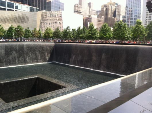 9/11 Memorial reflecting pool (w/ reflection of Freedom Tower off building straight ahead), August 5, 2014. (Donald Earl Collins).