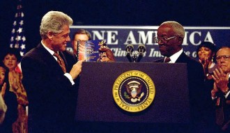 John Hope Franklin (1915-2009) handing President Bill Clinton the One America Report, ending role in Initiative on Race, White House, September 18, 1998. (http://clinton4.nara.gov via Wikipedia). In public domain.